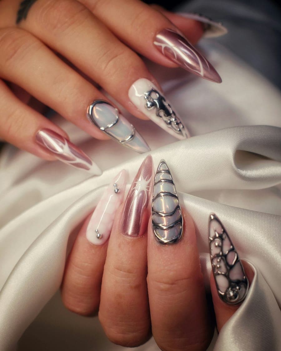 Unhas stiletto com efeito cromado e detalhes prateados sobre cetim