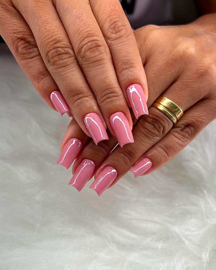 Unhas alongadas quadradas em rosa bebê sobre pelúcia branca