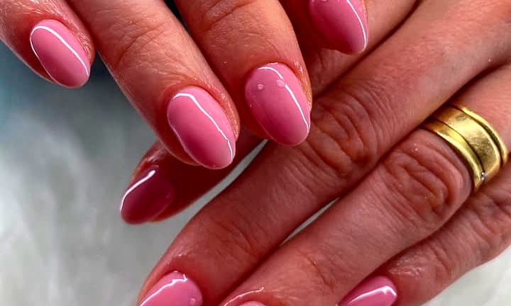 Unhas curtas arredondadas em rosa leitoso com brilho de espelho