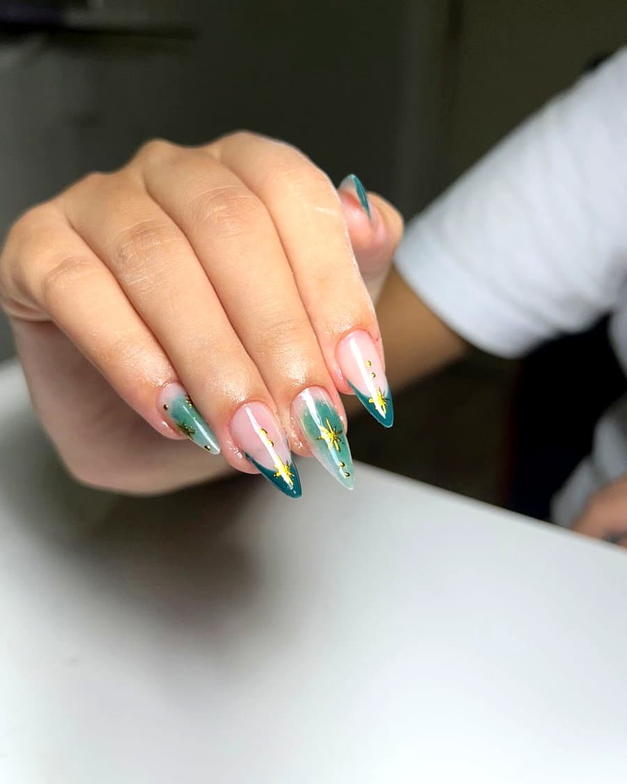 Unhas stiletto em verde esmeralda com estrelas douradas