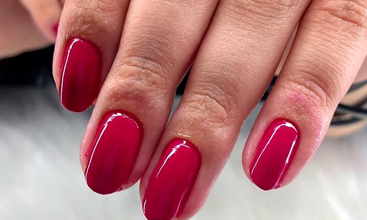 Unhas curtas em vermelho cereja com brilho intenso
